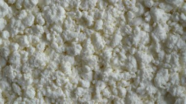 Süzme peynir arka plan, üst manzara, dönüşümlü. Süt ürünlerinin beyaz taneli dokusu, süzme peynir, yakın çekim. Süt ürünü konsepti