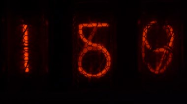 Cihazın üzerindeki vakum tüpü görüntüsü saniyeleri sayıyor. Vintage lamba zamanlayıcısında numaralar gösteriliyor, yakın çekim, nixie tüpü göstergesi. Parlama deşarj göstergesi