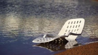 Mısır 'ın Sharm El Sheikh kentindeki tropikal bir plajda deniz suyunda beyaz plastik güneş dinleniyor. Seyahat ve doğa kavramı