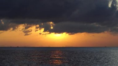 Tayland 'daki Koh Phangan adasında deniz suyunun üzerinde güzel bir günbatımı. Seyahat ve doğa kavramı. Akşam gökyüzü, bulutlar, güneş ve deniz suyu