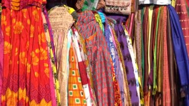 Udaipur, Rajasthan, Hindistan 'daki yerel sokak pazarında satılık renkli kıyafetlerin çeşitli ürünleri. Kapat.