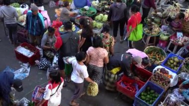 UBUD, BALI, INDONEZYA - 24 Nisan 2019: Endonezyalı fakir insanlar, Endonezya 'nın Bali adasındaki Ubud köyündeki sabah pazarında sağlıklı yiyecek satıyor ve satın alıyorlar. Sabah meyve ve sebze pazarı