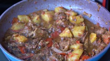 Soğanlı kızartma tavası, limon otu, kırmızı biber ve sığır eti, yakından. Endonezya 'da. Sambal Goreng Ati Kentang, Endonezya mutfağı, baharatlı biftek buluşması ve limon otu yaprağı ve kırmızı biberli patates garnitürü.