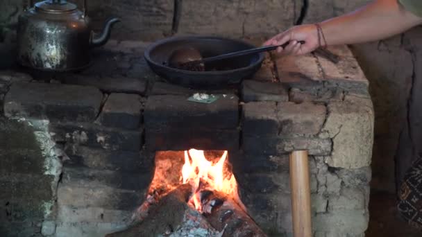 コーヒー粒は 地元のバリの家 ウブド バリ島 インドネシアのオープンファイアの陶器の鍋で焙煎されています キッチンの土鍋にコーヒー豆を炒めた 観光カフェで揚げコーヒー豆を調理 — ストック動画