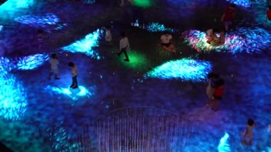 SINGAPORE CITY, SINGAPORE - MARCH 29, 2019: Large screen augmented reality experience on the floor. Children playing on Digital Light Canvas at Marina Bay Sands mall in Singapore