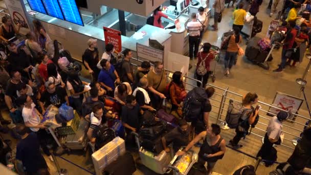 バンコク 2019年2月26日 タイのバンコクにあるドンムアン空港での出発のためのチェックインカウンターでの列に荷物スタンドと一緒に乗客の群衆 トップビュー — ストック動画