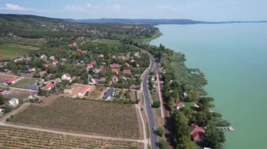 Balaton Gölü 'nün havadan görünüşü, su gölü boyunca arabalı yollar, evler, tarlalar ve Macaristan' daki bahçeler.