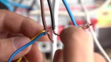 Erkek elektrikçi evdeki elektrik kablolarını bağlıyor, kapat. Elektrik kablolarının çok tehlikeli bağlantıları