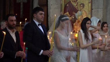 MTSKHETA, GEORGIA - OCTOBER 27, 2018 : Bride and groom with lighted candles get married in the Christian Orthodox Church in historic town Mtskheta near Tbilisi, Georgia