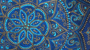Decorative ceramic plate with blue and golden colors, painted plates, close up, rotates, handmade. Decorative porcelain plate painted with acrylic paints, handwork