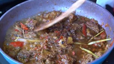 Soğanlı kızartma tavası, limon otu, kırmızı biber ve sığır eti, yakından. Endonezya 'da. Sambal Goreng Ati Kentang, Endonezya mutfağı, baharatlı biftek buluşması ve limon otu yaprağı ve kırmızı biberli patates garnitürü.