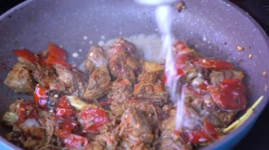 Soğanlı kızartma tavası, limon otu, kırmızı biber ve sığır eti, yakından. Endonezya 'da. Sambal Goreng Ati Kentang, Endonezya mutfağı, baharatlı biftek buluşması ve limon otu yaprağı ve kırmızı biberli patates garnitürü.