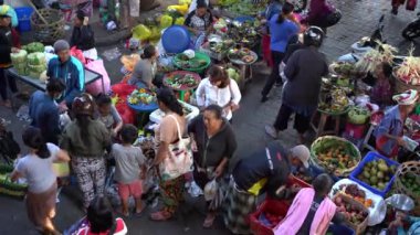 UBUD, BALI, INDONEZYA - 24 Nisan 2019: Endonezyalı fakir insanlar, Endonezya 'nın Bali adasındaki Ubud köyündeki sabah pazarında sağlıklı yiyecek satıyor ve satın alıyorlar. Sabah meyve ve sebze pazarı