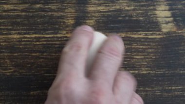 Chicken egg rotates on a wooden table, close up, top view