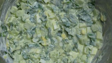 Sağlıklı yeşil pırasa salatası, haşlanmış yumurta, salatalık ve ekşi krema kasede, yakın plan, üst manzara. Haşlanmış yumurtalı yabani sarımsak ya da Ramson salatası.