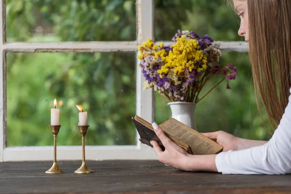 Young Girl Reads Old Book Windowsill Next Window Two Burning Royaltyfria Stockfoton