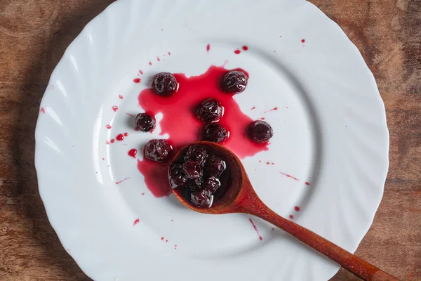 Red Cherry Jam White Plate Wooden Spoon Close Top View — Stockfoto