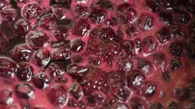 Preparation of freshly picked red cherries with sugar to make cherry jam, close up, top view. Cooking homemade cherry fruit jam in a saucepan
