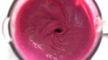 Tropik kırmızı ejderha meyvesi ve beyaz hindistan cevizi sütüyle karıştırılmış tatlı muz. Pembe meyve kokteyli. Sağlıklı yaşam tarzı kavramı. Yakın çekim, yavaş çekim, üst görünüm