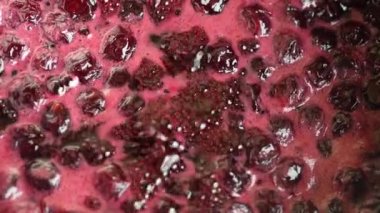 Kiraz reçeli yapmak için taze toplanmış kırmızı kirazlı şekerin hazırlanması, yakın plan, üst manzara. Tencerede ev yapımı kiraz reçeli pişirmek.