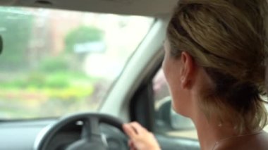 Yağmurda araba süren genç bir kadın, yakın çekim. Zanzibar Adası, Tanzanya, Doğu Afrika, yavaş çekim