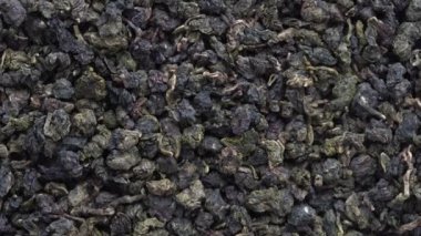 Green tea leaves background. Oolong tea rotates. Abstract food textures. Close up, top view. The high end tea of Vietnam