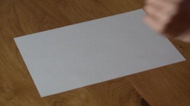 Girl on a white sheet draws a question mark with a black marker . Writing question mark, close up