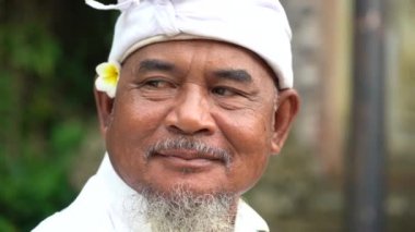 UBUD, BALI, INDONESIA - MARCH 6, 2019 : Unidentified Indonesian man at holy temple during the religious ceremony in Ubud, island Bali, Indonesia. Close up portrait