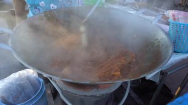 Sokak yemekleri, Taylandlı adam Tayland 'daki Koh Phangan adasında Tofulu erişte pişiriyor.