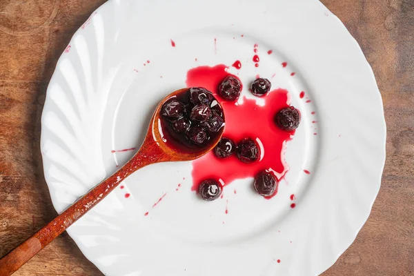 Red Cherry Jam White Plate Wooden Spoon Close Top View — Stockfoto
