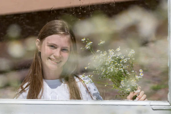 Piękna Dziewczyna Patrząc Przez Okno Kroplami Deszczu Szkle Bukietem Kwiatów — Zdjęcie stockowe