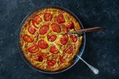 Kırmızı domatesli nefis vejetaryen kabaklı turta, üst manzara, yakın çekim. Yumurta, un ve ekşi kremayla rendelenmiş kabak ve tüm bunlar fırında pişmiş.