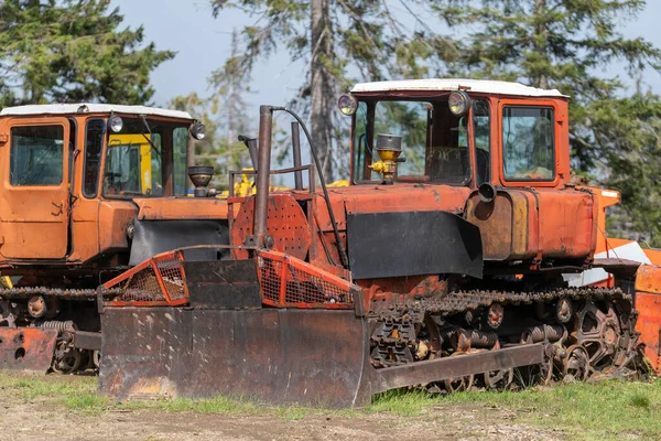 Old bulldozer on a sunny day with a bucket to move the earth in an abandoned factory, close up . Ukraine, Europe