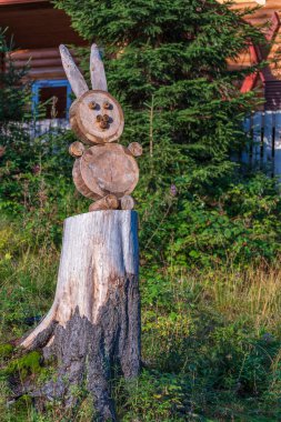 Wooden hare from a felled tree on a stump along the road in the Carpathian mountains, close up . Ukraine, Europe
