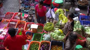 UBUD, BALI, INDONEZYA - 27 Nisan 2019: Endonezyalı fakir insanlar, Endonezya 'nın Bali adasındaki Ubud köyündeki sabah pazarında sağlıklı yiyecek satıyor ve satın alıyorlar. Sabah meyve ve sebze pazarı