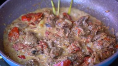 Soğanlı kızartma tavası, limon otu, kırmızı biber ve sığır eti, yakından. Endonezya 'da. Sambal Goreng Ati Kentang, Endonezya mutfağı, baharatlı biftek buluşması ve limon otu yaprağı ve kırmızı biberli patates garnitürü.