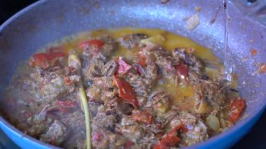 Soğanlı kızartma tavası, limon otu, kırmızı biber ve sığır eti, yakından. Endonezya 'da. Sambal Goreng Ati Kentang, Endonezya mutfağı, baharatlı biftek buluşması ve limon otu yaprağı ve kırmızı biberli patates garnitürü.