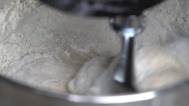 Kneading dough using a kitchen machine. Making yeast-free bread with the table stand mixer. Kitchen aid kneads flour to make dough, close up