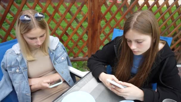 Relaxed Two Young Girls Using Smartphone Surfing Social Media Checking — Vídeo de Stock
