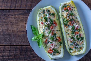 Zucchini stuffed with shrimps, vegetables and cheese. Baked zucchini boats, copy space, top view, close up