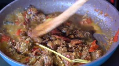 Soğanlı kızartma tavası, limon otu, kırmızı biber ve sığır eti, yakından. Endonezya 'da. Sambal Goreng Ati Kentang, Endonezya mutfağı, baharatlı biftek buluşması ve limon otu yaprağı ve kırmızı biberli patates garnitürü.