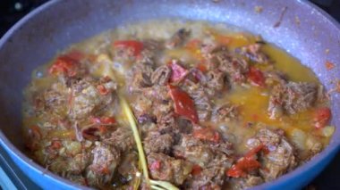 Soğanlı kızartma tavası, limon otu, kırmızı biber ve sığır eti, yakından. Endonezya 'da. Sambal Goreng Ati Kentang, Endonezya mutfağı, baharatlı biftek buluşması ve limon otu yaprağı ve kırmızı biberli patates garnitürü.