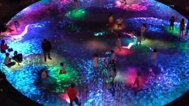 SINGAPORE CITY, SINGAPORE - MARCH 29, 2019: Large screen augmented reality experience on the floor. Children playing on Digital Light Canvas at Marina Bay Sands mall in Singapore
