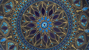 Dekoratif seramik tabak, siyah, mavi ve altın renkli, arka planda boyalı, yakın plan, üst manzara, döndürme. Akrilik boyalarla boyanmış dekoratif porselen tabaka, el işi, nokta boyası.