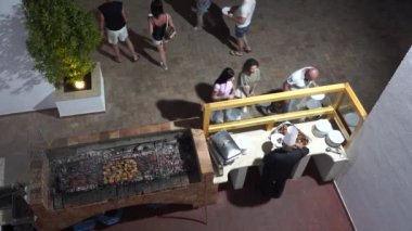 Sharm El Sheikh, Mısır - 19 Mayıs 2021: Mısırlı şef, Mısır 'daki bir restorandaki her şeyi kapsayan sisteme göre tatilde olan turistler için açık ateşte kokulu tavuk bacağı hazırlıyor