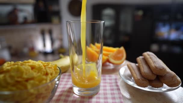 将新鲜的橙汁倒入厨房里旋转桌子上的透明玻璃杯中 慢动作 用天然有机维生素饮料烹调健康早餐 — 图库视频影像