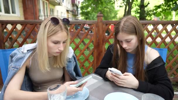 Relaxed Two Young Girls Using Smartphone Surfing Social Media Checking — стоковое видео