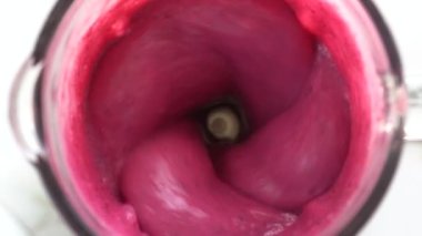 Tropik kırmızı ejderha meyvesi ve beyaz hindistan cevizi sütüyle karıştırılmış tatlı muz. Pembe meyve kokteyli. Sağlıklı yaşam tarzı kavramı. Yakın çekim, yavaş çekim, üst görünüm