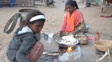 PUSHKAR, INDIA - 14 Kasım 2018: Hintli genç kız kutsal şehir Pushkar, Rajasthan, Hindistan yakınlarındaki avluda chapati için hamur hazırlıyor.