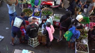 UBUD, BALI, INDONEZYA - 24 Nisan 2019: Endonezyalı fakir insanlar, Endonezya 'nın Bali adasındaki Ubud köyündeki sabah pazarında sağlıklı yiyecek satıyor ve satın alıyorlar. Sabah meyve ve sebze pazarı